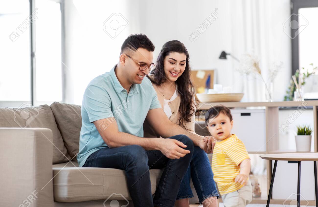 152008329-happy-family-with-child-sitting-on-sofa-at-home.jpg